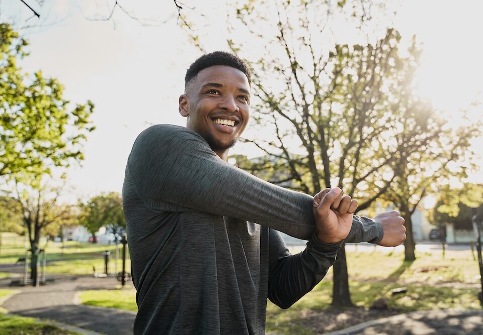 young man stretching and smiling